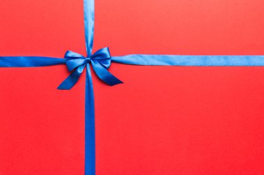 Mor kurdelenin üst görüntüsü yuvarlandı ve pembe fiyonk renkli arka planda izole edildi. Kopyalama alanı olan düz.