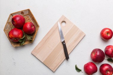 Yeşil yapraklı taze kırmızı elmalar. Bıçakla kesme tahtası. Üst görünüm.