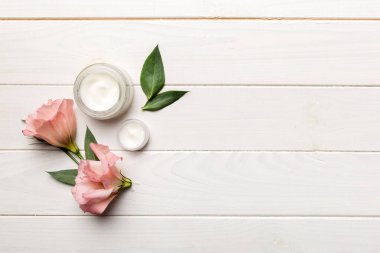 Ahşap zemin üzerinde yeşil yapraklar olan organik kozmetik ürünler. Uzayı kopyala, düz yat.