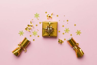 Renkli arka planda parlak konfetileri olan Noel krakerleri, üst görünüm, boşluk kopyala.