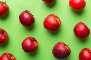 Renkli arka planda bir sürü kırmızı elma, üst manzara. Görüş üzerinde taze elma ile sonbahar deseni.