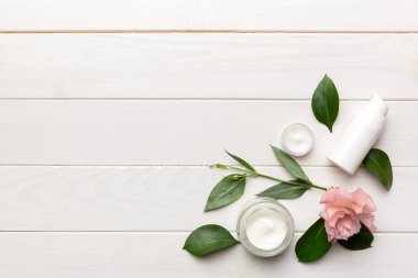 Ahşap zemin üzerinde yeşil yapraklar olan organik kozmetik ürünler. Uzayı kopyala, düz yat.