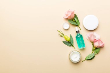 Kozmetik ürünleri ve ahşap arka planda güzel güller olan kompozisyon. Uzayı kopyala, düz yat.