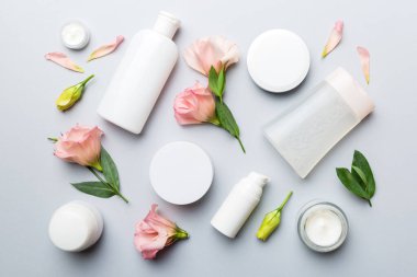 Renkli arka planda kozmetik ürünleri ve güzel güller olan kompozisyon. Düz yatıyordu.