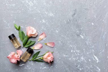 Kozmetik ürünleri ve çimento arka planında güzel güller olan kompozisyon. Uzayı kopyala, düz yat.