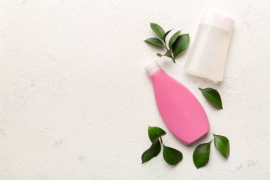 Çimento arka planında yeşil yaprakları olan organik kozmetik ürünler. Uzayı kopyala, düz yat.