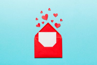 Renkli arka planda beyaz kart ve kalp olan kırmızı kağıt zarf. Top view Sevgililer Günü konsepti.