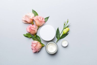 Renkli arka planda kozmetik ürünleri ve güzel güller olan kompozisyon. Düz yatıyordu.