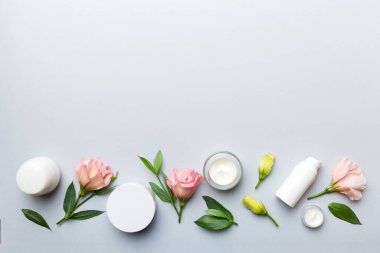 Kozmetik ürünleri ve ahşap arka planda güzel güller olan kompozisyon. Uzayı kopyala, düz yat.