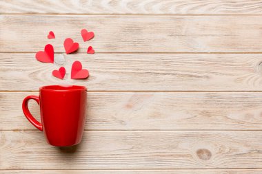 Renkli arka planda kırmızı bardak, kırmızı küçük kalpler, kopya alanı ile üst görünüm.