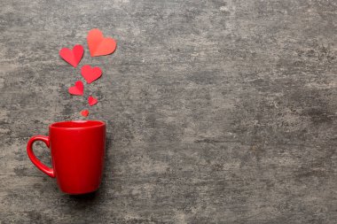 Renkli arka planda kırmızı bardak, kırmızı küçük kalpler, kopya alanı ile üst görünüm.