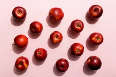 Renkli arka planda bir sürü kırmızı elma, üst manzara. Görüş üzerinde taze elma ile sonbahar deseni.