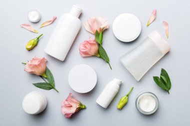 Renkli arka planda kozmetik ürünleri ve güzel güller olan kompozisyon. Düz yatıyordu.