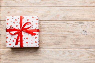 Sevgililer Günü kompozisyonu: Yay ve kalple kırmızı hediye kutusu. Noel hediyesi. Yukarıdan bak. Mesaj için yer var. Holday tebrik kartı.