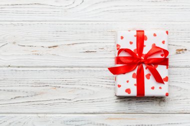 Sevgililer Günü kompozisyonu: Yay ve kalple kırmızı hediye kutusu. Noel hediyesi. Yukarıdan bak. Mesaj için yer var. Holday tebrik kartı.