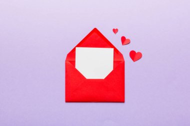 Renkli arka planda beyaz kart ve kalp olan kırmızı kağıt zarf. Top view Sevgililer Günü konsepti.