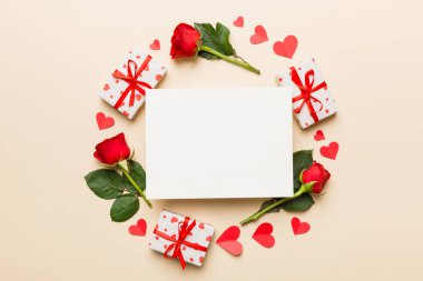 Renkli arka planda gül, oyuncak kutusu, kalp ve boş tebrik kartı modelinden yapılmış bir çerçeve. Top view, flat lay, copy space Holiday, Anneler Günü, doğum günü konsepti.