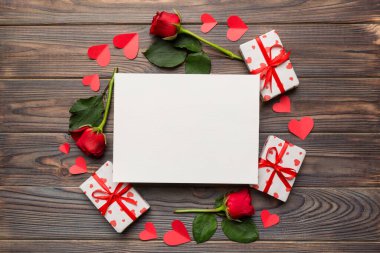 Renkli arka planda gül, oyuncak kutusu, kalp ve boş tebrik kartı modelinden yapılmış bir çerçeve. Top view, flat lay, copy space Holiday, Anneler Günü, doğum günü konsepti.