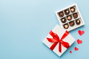 Sevgililer Günü için kırmızı kutuda lezzetli çikolatalı pralinler. Kalp şeklinde çikolata kutusu, fotokopi alanı ile üst görünüm..