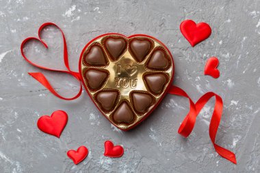 Sevgililer Günü için kırmızı kutuda lezzetli çikolatalı pralinler. Kalp şeklinde çikolata kutusu, fotokopi alanı ile üst görünüm..