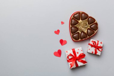 Sevgililer Günü için kutuda lezzetli çikolatalı pralinler. Kalp, hediye kutusuyla şekillendirilmiş çikolatalar fotokopi alanı ile üst görünüm.