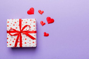 Sevgililer Günü kompozisyonu: Yay ve kalple kırmızı hediye kutusu. Noel hediyesi. Yukarıdan bak. Mesaj için yer var. Holday tebrik kartı.