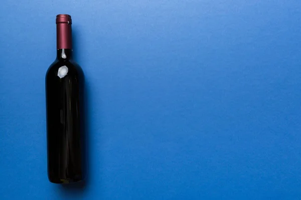 着色テーブルの上に赤ワインの1本 フラットレイアウト コピースペース付きのトップビュー — ストック写真