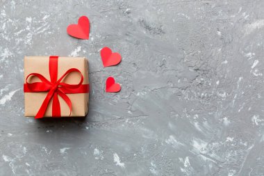 Sevgililer Günü kompozisyonu: Yay ve kalple kırmızı hediye kutusu. Noel hediyesi. Yukarıdan bak. Mesaj için yer var. Holday tebrik kartı.