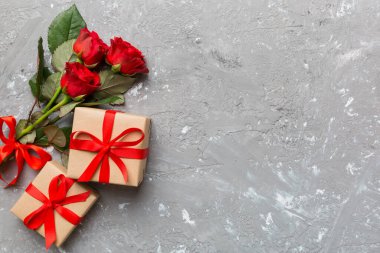 Gül çiçeği, kırmızı kalp ve hediye kutularıyla Sevgililer Günü kompozisyonu. Anneler günü ve doğum günü tebriği, kopyalama alanı, üst görünüm.