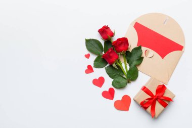 Zarflı sevgililer günü kompozisyonu, gül çiçeği ve kırmızı kalp masada. Üst görünüm, düz görünüm, kopyalama alanı Tatil kavramı.