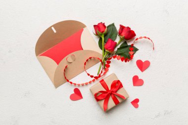 Zarflı sevgililer günü kompozisyonu, gül çiçeği ve kırmızı kalp masada. Üst görünüm, düz görünüm, kopyalama alanı Tatil kavramı.