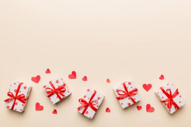 Sevgililer Günü kompozisyonu: Yay ve kalple kırmızı hediye kutusu. Noel hediyesi. Yukarıdan bak. Mesaj için yer var. Holday tebrik kartı.