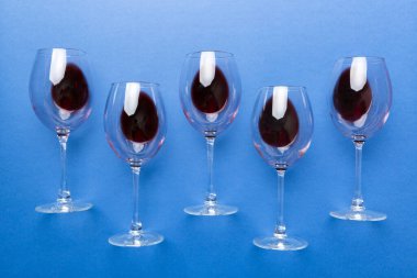 Şarap tadımında bir sürü kırmızı şarap. Renkli arka planda kırmızı şarap kavramı. Üst görünüm, düz dizayn.