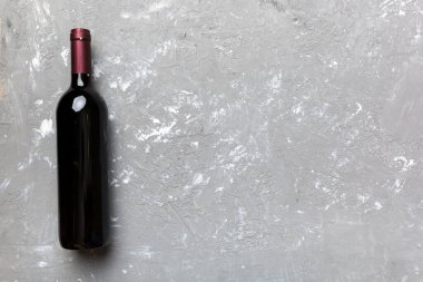 Renkli masada bir şişe kırmızı şarap. Düz konum, üst görünüm kopyalama alanı.