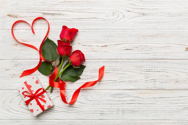 Masada gül çiçeği ve kırmızı kalple Sevgililer Günü kompozisyonu. Üst görünüm, düz görünüm, kopyalama alanı Tatil kavramı.