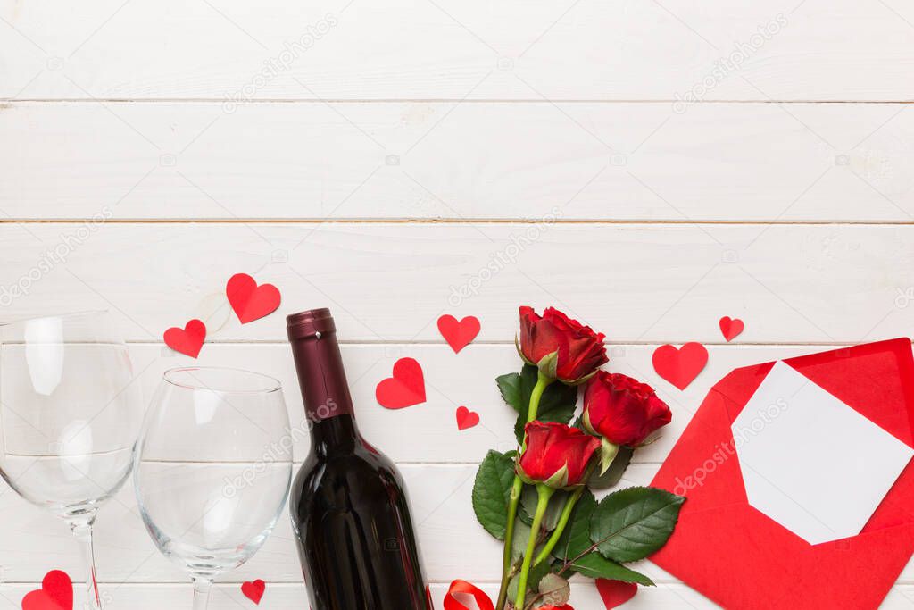 Valentine's day composition with red wine, rose flower and gift box on table. Top view, flat lay. Holiday concept.