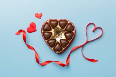 Sevgililer Günü için kırmızı kutuda lezzetli çikolatalı pralinler. Kalp şeklinde çikolata kutusu, fotokopi alanı ile üst görünüm..