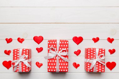 Sevgililer Günü kompozisyonu: Yay ve kalple kırmızı hediye kutusu. Noel hediyesi. Yukarıdan bak. Mesaj için yer var. Holday tebrik kartı.