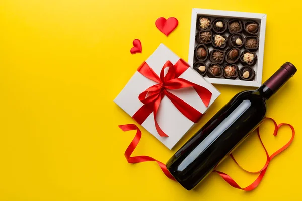Бутылка Красного Вина Цветном Фоне День Святого Валентина Подарком Шоколадом — стоковое фото