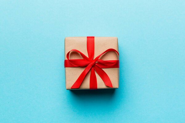 Состав ко Дню Святого Валентина: красный подарочный коробок с луком и сердцем. Рождественский подарок. Вид сверху. Пространство для текста. Поздравительная открытка.