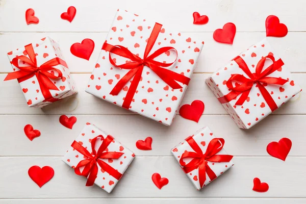 バレンタインデーの組成背景 弓と心を持つ赤いギフトボックス クリスマスプレゼント 上からの眺め ホリデーグリーティングカード — ストック写真
