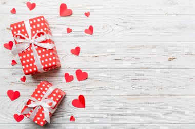 Sevgililer Günü kompozisyonu: Yay ve kalple kırmızı hediye kutusu. Noel hediyesi. Yukarıdan bak. Mesaj için yer var. Holday tebrik kartı.