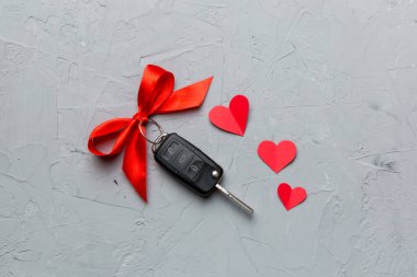 Kırmızı kurdeleli ve renkli masada kalbi olan araba anahtarı. Sevgililer Günü ya da Noel hediyesi vermek, Kopya Alanı ile Üst Görünüm.