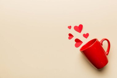 Renkli arka planda kırmızı bardak, kırmızı küçük kalpler, kopya alanı ile üst görünüm.