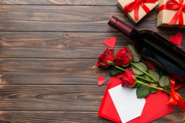 Kırmızı şarap, gül çiçeği ve hediye kutusuyla Sevgililer Günü kompozisyonu. Üst manzara, düz yatış. Tatil kavramı.