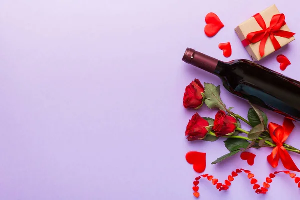 テーブルの上に赤いワイン バラの花とギフトボックスとバレンタインデーの組成 トップビュー フラットレイアウト 休日のコンセプト — ストック写真