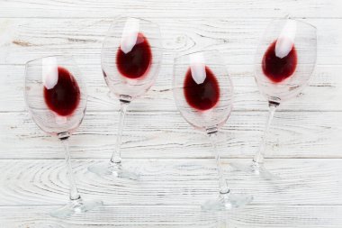 Şarap tadımında bir sürü kırmızı şarap. Renkli arka planda kırmızı şarap kavramı. Üst görünüm, düz dizayn.