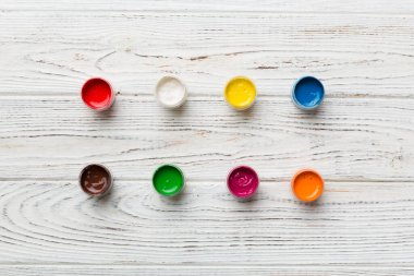 Renkli arka planda farklı renkte gagalı kavanozlar. Hobi resim. Boşluğu olan üst görünüm. Yaratıcılık için işyeri. ev öğretmenliği kavramı çizimi.