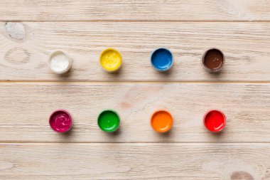 Renkli arka planda farklı renkte gagalı kavanozlar. Hobi resim. Boşluğu olan üst görünüm. Yaratıcılık için işyeri. ev öğretmenliği kavramı çizimi.