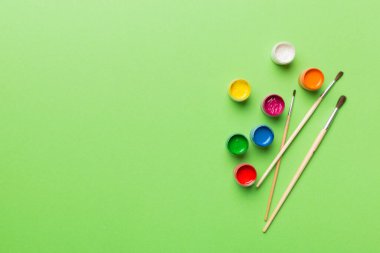 Boya ve fırçalı palet, yakın çekim. Boşluğu olan üst görünüm. Yaratıcılık için işyeri. ev öğretmenliği kavramı çizimi.